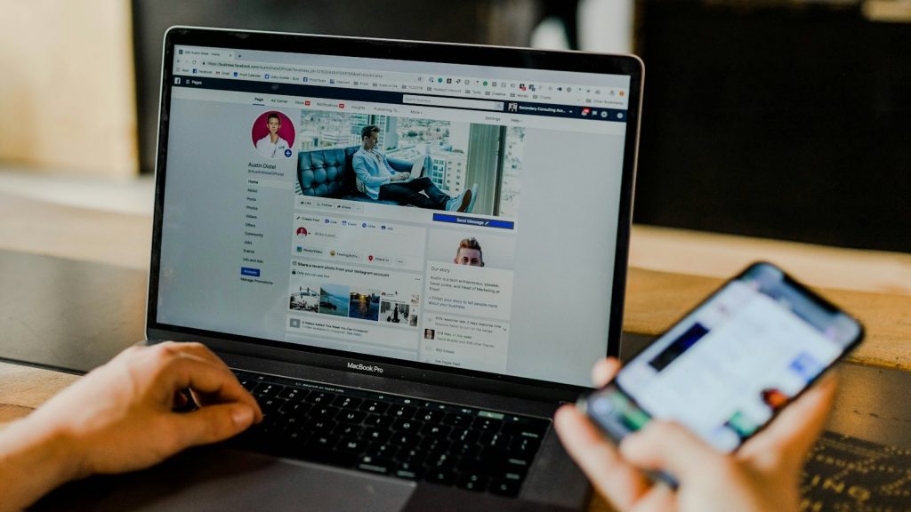 Persona revisando campañas de publicidad en el portátil y el móvil